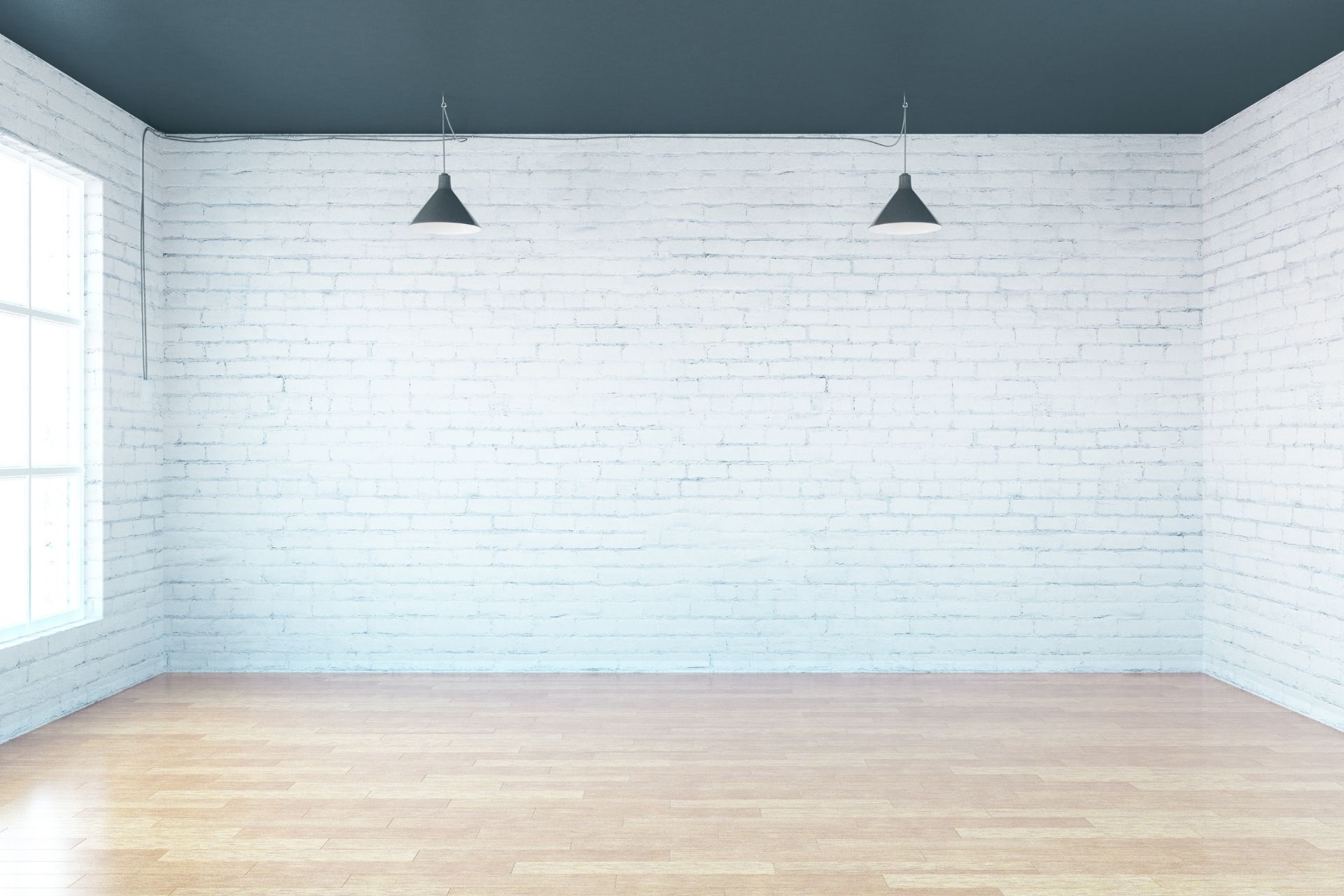 empty room with a window, two light fixtures and exposed white brickwork