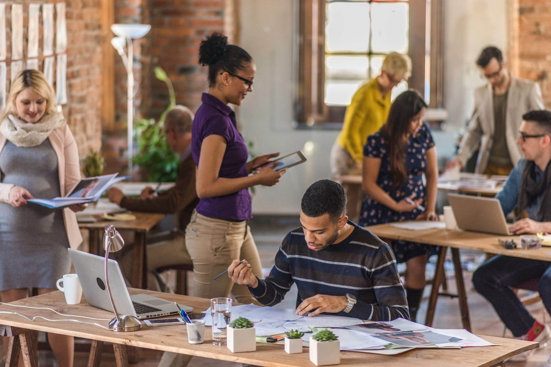 group of professionals in an office working around each other.