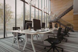 tall office with shared desk, office chairs and big windows.