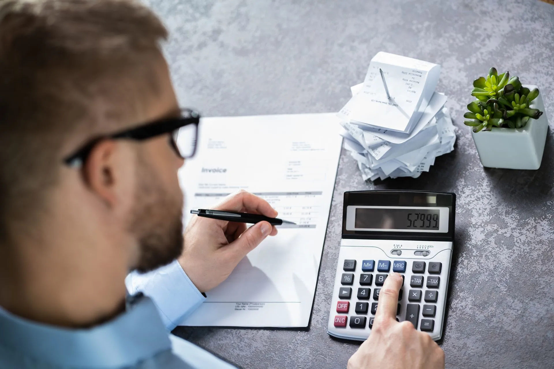 Businessman calculating expenses in office