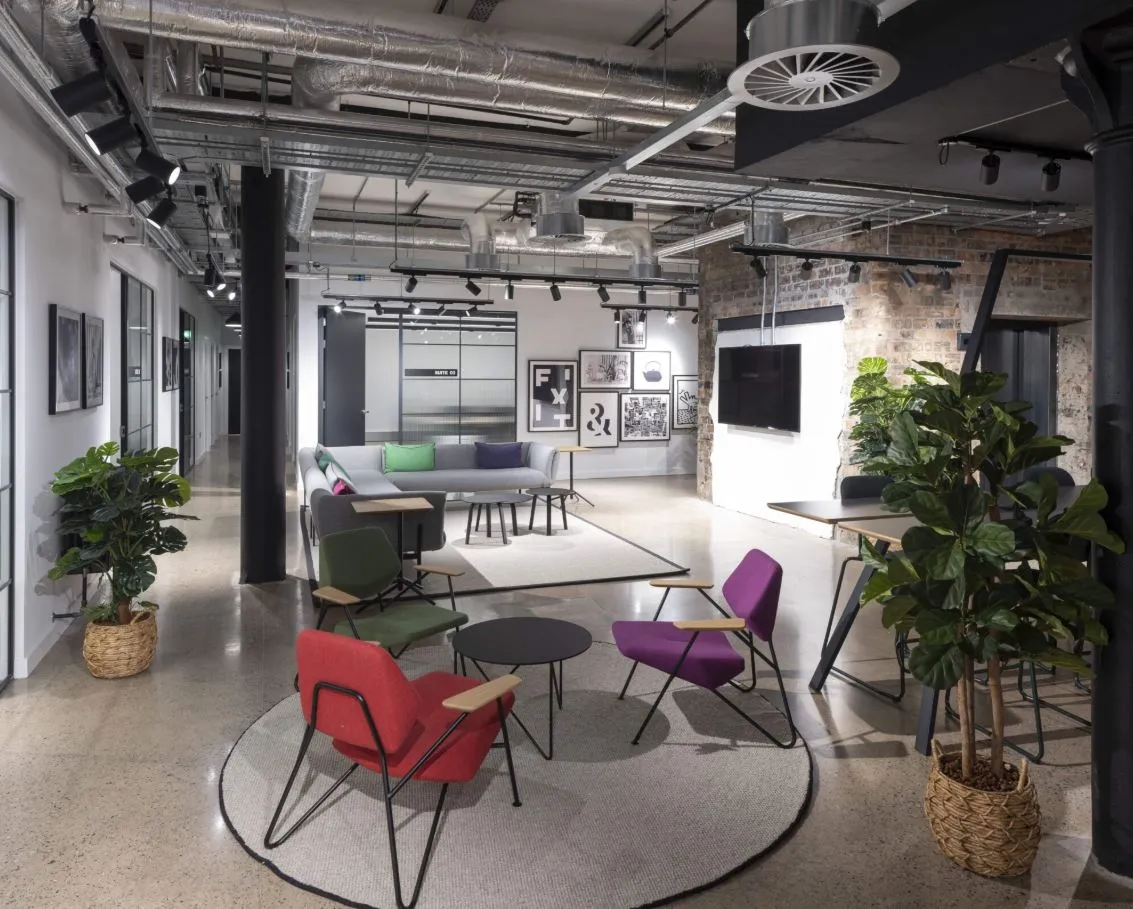 Coworking lounge at The Garment Factory with exposed brick and breakout seating