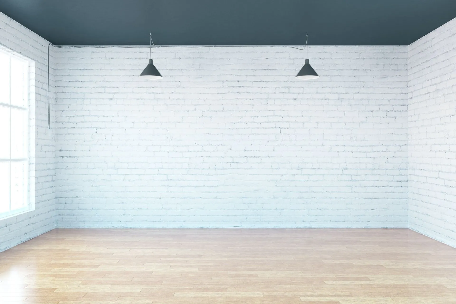 empty room with a window, two light fixtures and exposed white brickwork