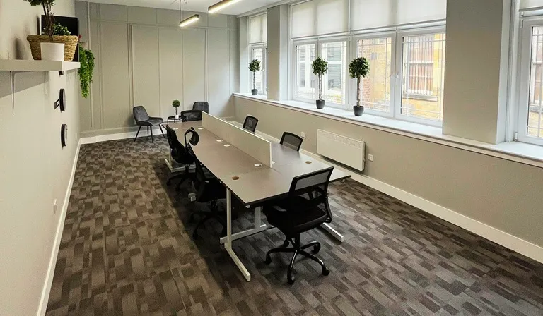 Suite 15 at Kollaborate House with a long shared desk and plants