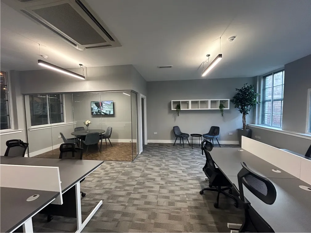 Suite 4 at Kollaborate House with desk pods and a meeting table
