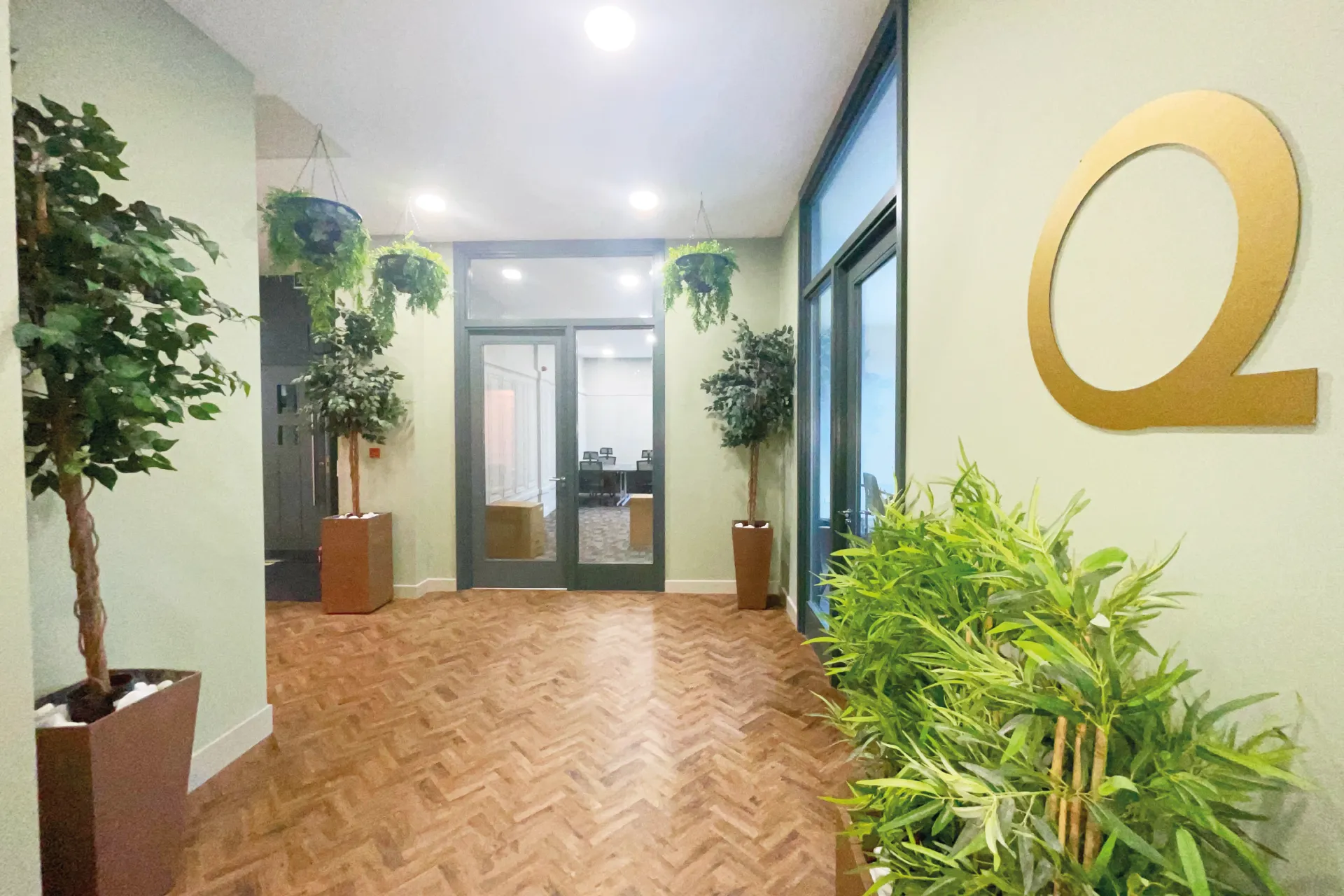 Corridor at Kollaborate House with the gold Q emblem and herringbone floor