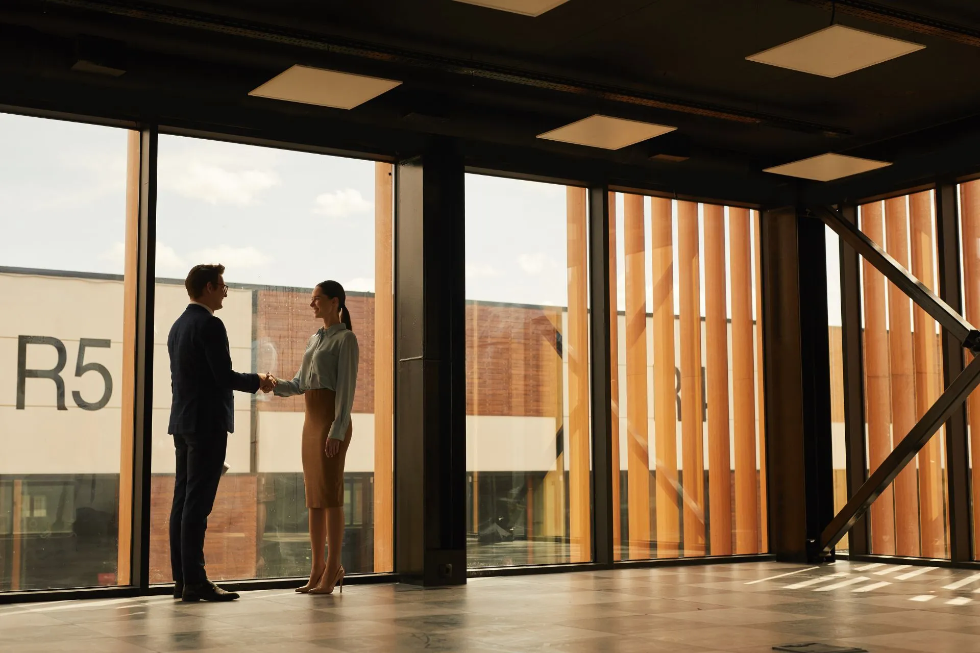 Shaking hands while standing in empty office building