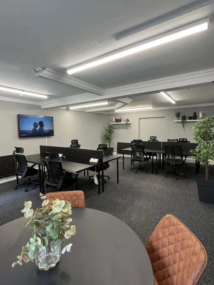 Suite 1 at The Townhouse laid out with desks facing a wall-mounted screen