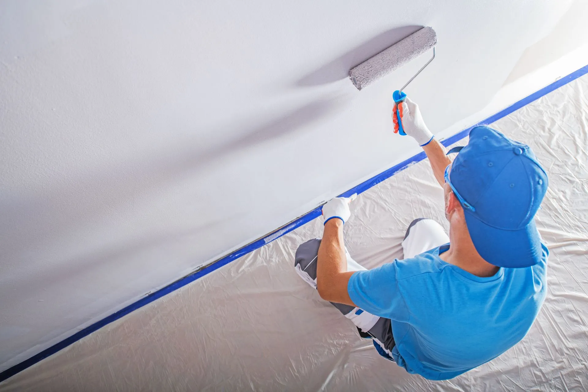 Decorator repainting an office wall during dilapidation works