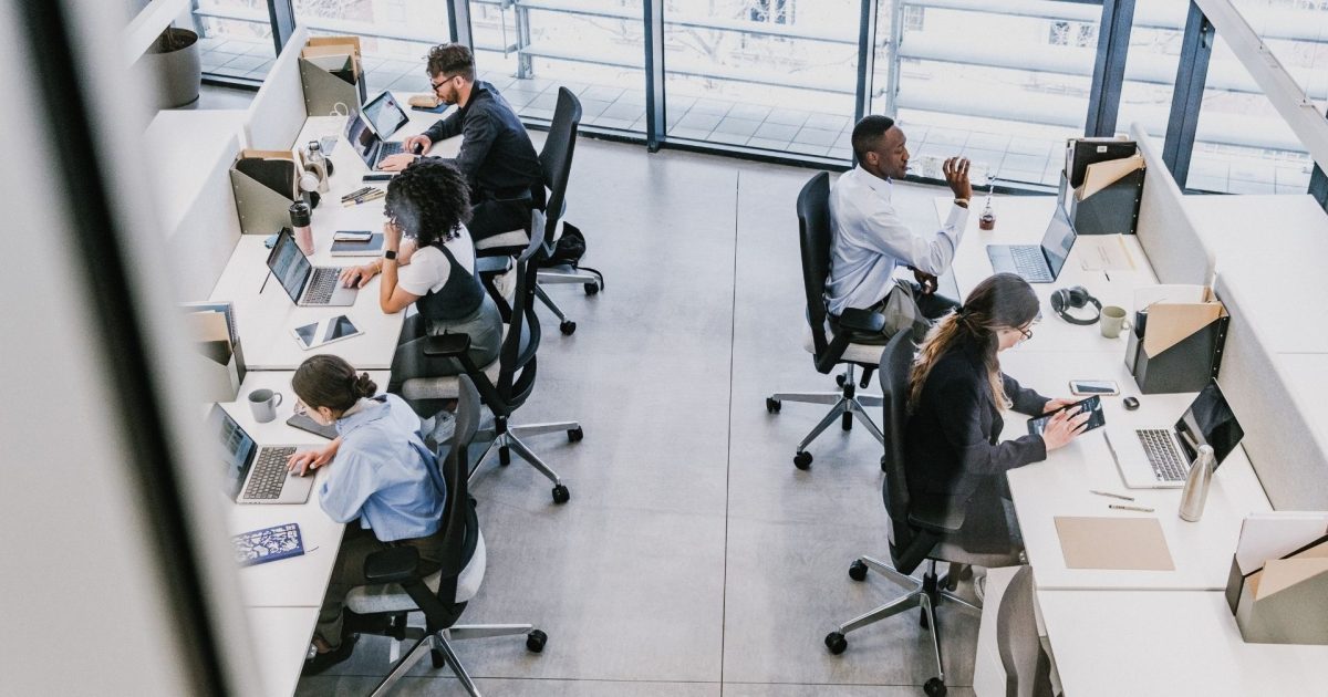 group of employees working at desk from a top-down view
